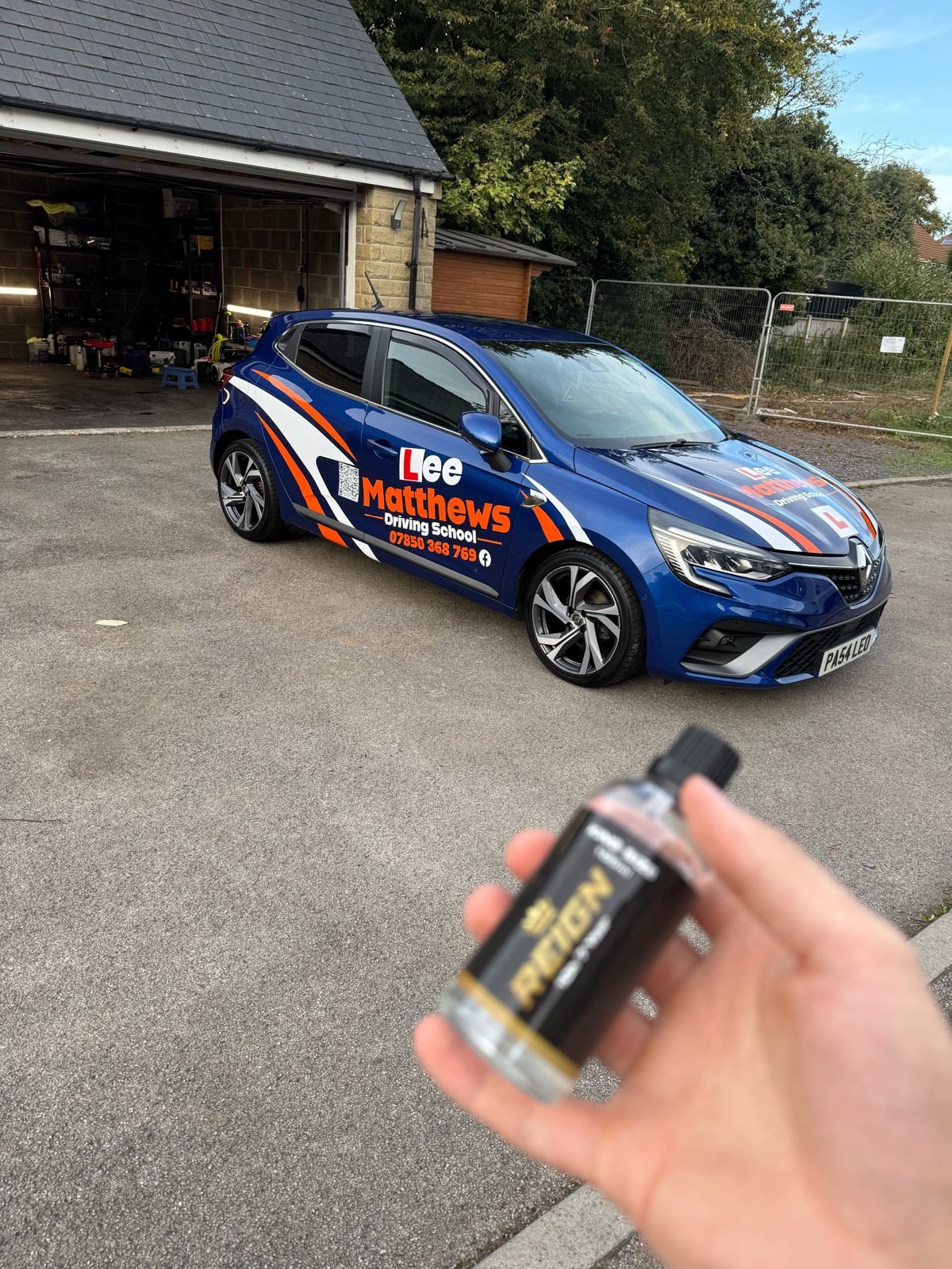 Blue Lee Matthews Driving School Clio at the open Glapwell unit with a REIGN ceramic bottle in the foreground